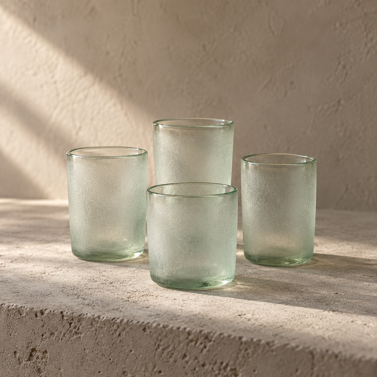 Four kiln-formed glass tumblers, etched matte exterior, polished rim.